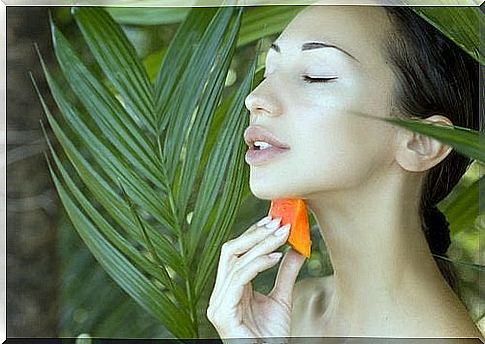 Woman enjoying the main benefits for the skin of papaya fruit