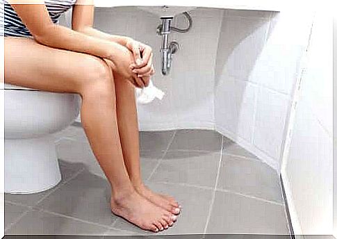 Woman sitting on the toilet bowl